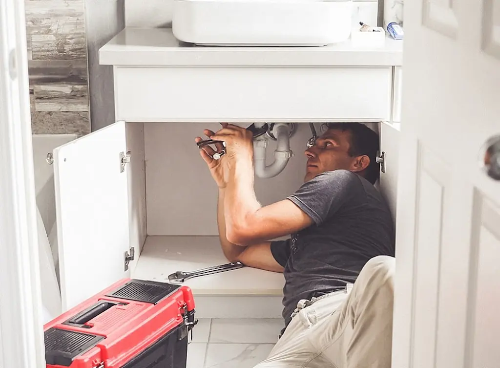 SwiftFlow plumber fitting a copper pipe under a North London kitchen sink